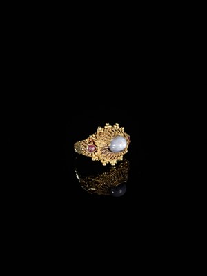 Lot 657 - A GOLD PRIEST’S RING INLAID WITH A MOONSTONE AND TWO SMALL GARNETS
