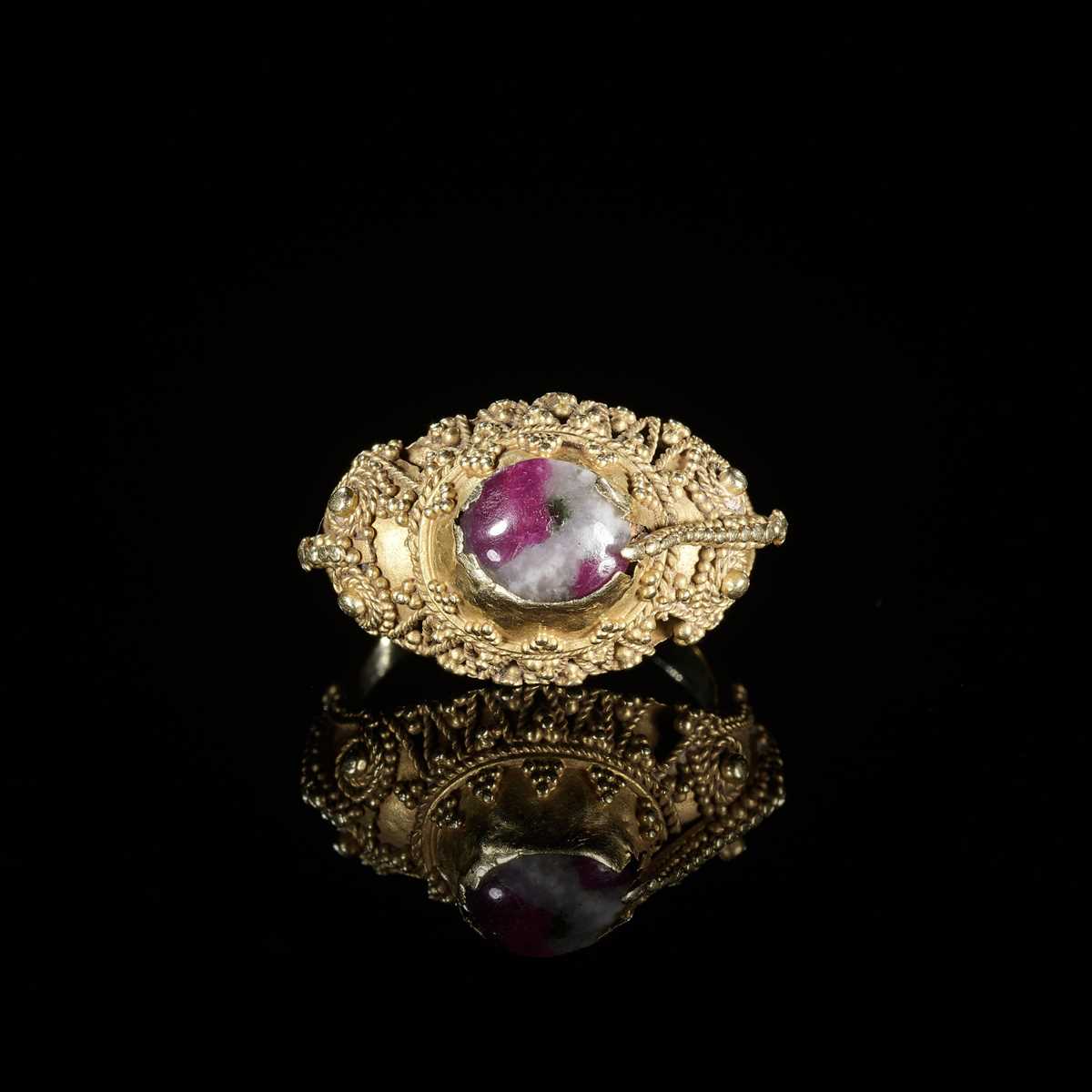 Lot 311 - A CORUNDUM-SET GOLD ‘FLOWERS AND BIRD’ PRIEST’S RING