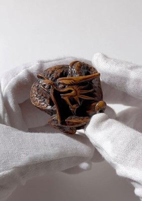 Lot 325 - A WOOD NETSUKE OF A COILED DRAGON WITH TAMA