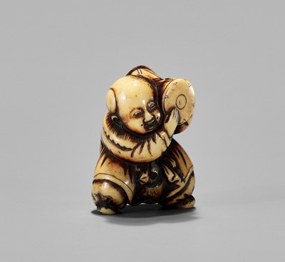 Lot 471 - AN ANTLER NETSUKE OF A BOY WITH DRUM, 19th CENTURY