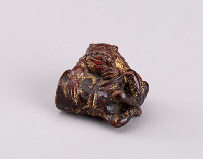 Lot 788 - A LACQUERED WOOD NETSUKE OF AN ONI WITH RASHOMON ARM, EDO PERIOD