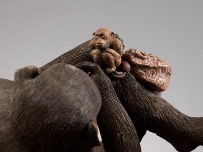 Lot 256 - A RARE AND LARGE PAINTED POTTERY OKIMONO OF A MONKEY EXAMINING A MONKEY NETSUKE