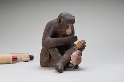 Lot 256 - A RARE AND LARGE PAINTED POTTERY OKIMONO OF A MONKEY EXAMINING A MONKEY NETSUKE