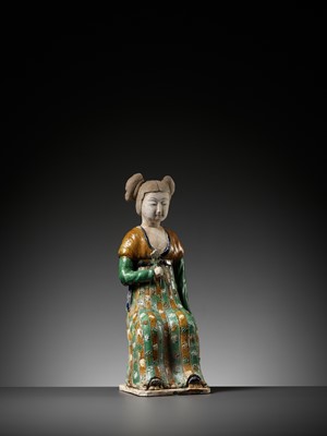Lot 1192 - A RARE SANCAI-GLAZED POTTERY FIGURE OF A SEATED COURT LADY, TANG DYNASTY OR LATER