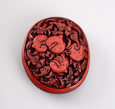 A TSUISHU (CARVED RED LACQUER) MANJU NETSUKE WITH PEACHES AND BATS