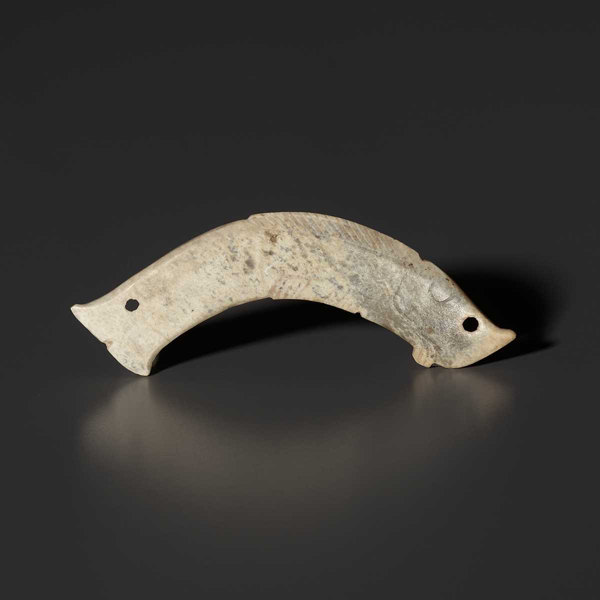 Lot 29 - A PALE CELADON JADE ‘FISH’ PENDANT, LATE SHANG TO WESTERN ZHOU DYNASTY