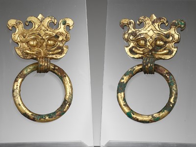 Lot 493 - A PAIR OF GILT-BRONZE TAOTIE MASK FITTINGS WITH LOOSE RING HANDLES, WARRING STATES PERIOD TO HAN DYNASTY