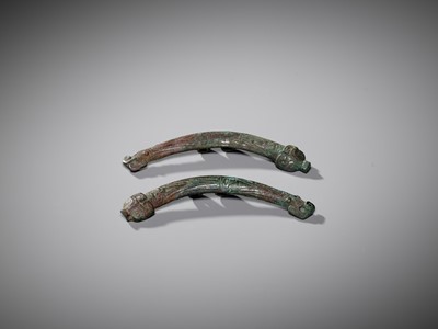 Lot 463 - A PAIR OF ‘DRAGON AND TAOTIE MASK’ BRONZE CHEEK-PIECE FITTINGS, ZHOU DYNASTY