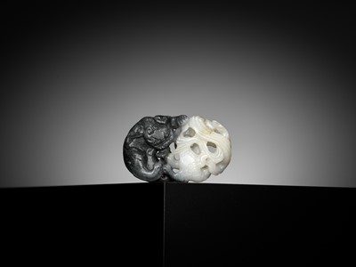 Lot 330 - A BLACK AND WHITE JADE ‘BUDDHIST LIONS’ PENDANT, 18TH CENTURY