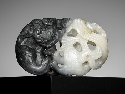 Lot 330 - A BLACK AND WHITE JADE ‘BUDDHIST LIONS’ PENDANT, 18TH CENTURY