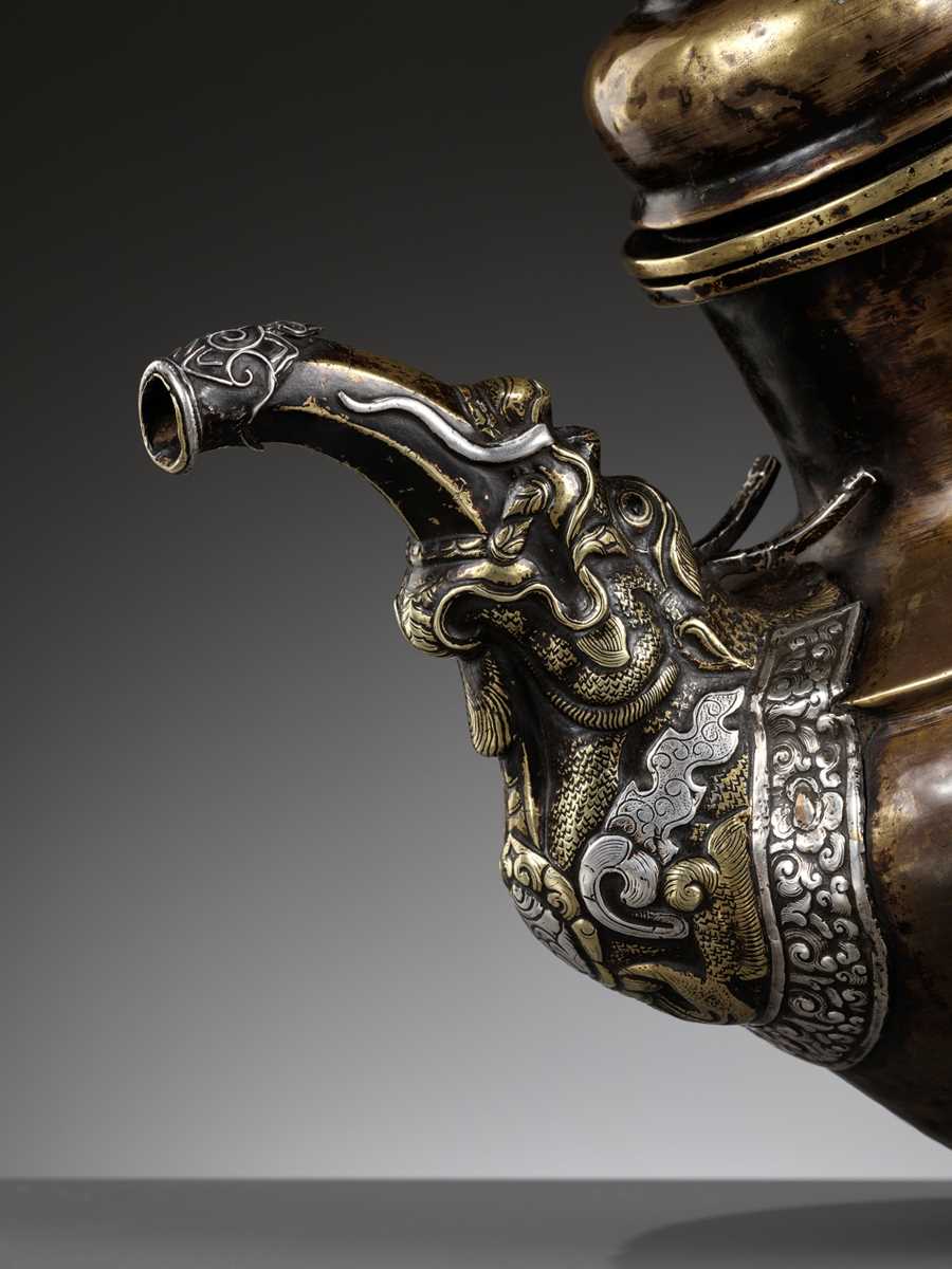 Lot 525 - A PARCEL-GILT AND SILVER-APPLIED BRASS