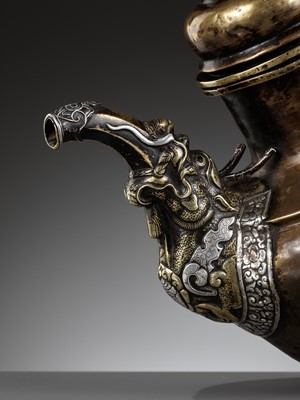 Lot 525 - A PARCEL-GILT AND SILVER-APPLIED BRASS RITUAL TEAPOT