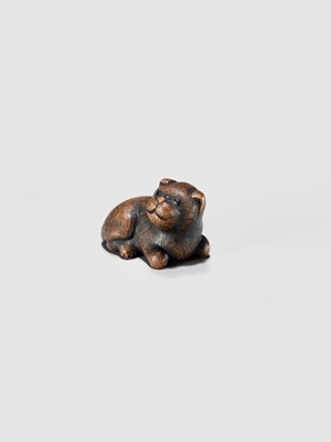 Lot 372 - A TANBA SCHOOL WOOD NETSUKE OF A RECLINING PUPPY