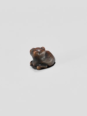 Lot 372 - A TANBA SCHOOL WOOD NETSUKE OF A RECLINING PUPPY