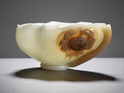 Lot 47 - A WHITE AND BROWN JADE ‘LOTUS, CRAB AND MILLET’ BRUSH WASHER AND MATCHING WOOD STAND, 18TH CENTURY