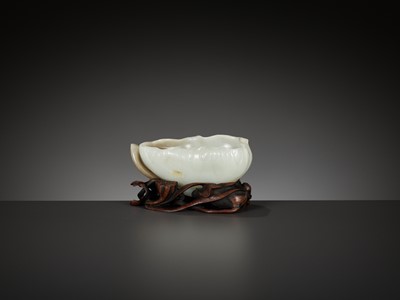 Lot 47 - A WHITE AND BROWN JADE ‘LOTUS, CRAB AND MILLET’ BRUSH WASHER AND MATCHING WOOD STAND, 18TH CENTURY