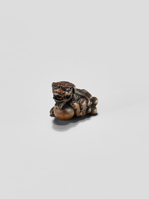 Lot 310 - A WOOD NETSUKE OF A SHISHI WITH BALL