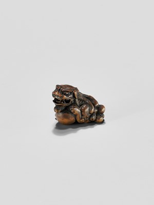 Lot 310 - A WOOD NETSUKE OF A SHISHI WITH BALL