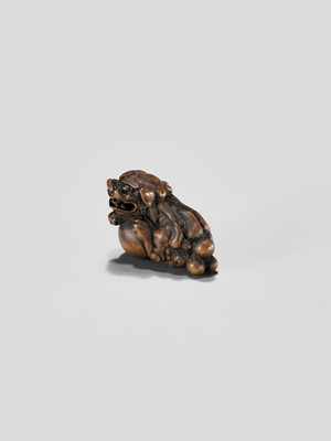 Lot 310 - A WOOD NETSUKE OF A SHISHI WITH BALL