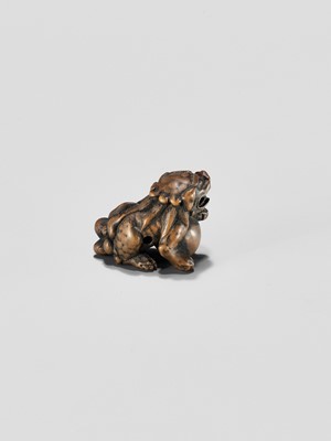 Lot 310 - A WOOD NETSUKE OF A SHISHI WITH BALL