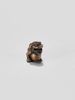 Lot 310 - A WOOD NETSUKE OF A SHISHI WITH BALL