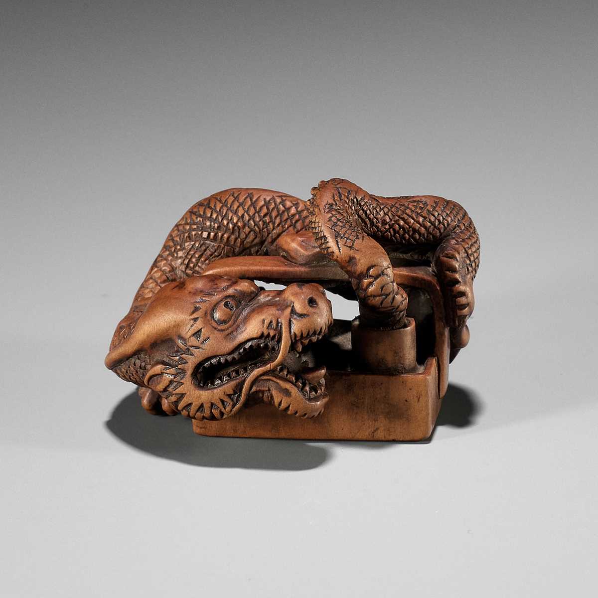 Lot 326 - A WOOD NETSUKE OF A DRAGON EMERGING FROM AN ASH POT (HAIFUKI KARA RYU)