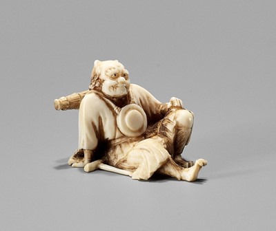 Lot 901 - YOSHIAKI: AN IVORY OKIMONO NETSUKE OF AN ONI NEMBUTSU, MEIJI