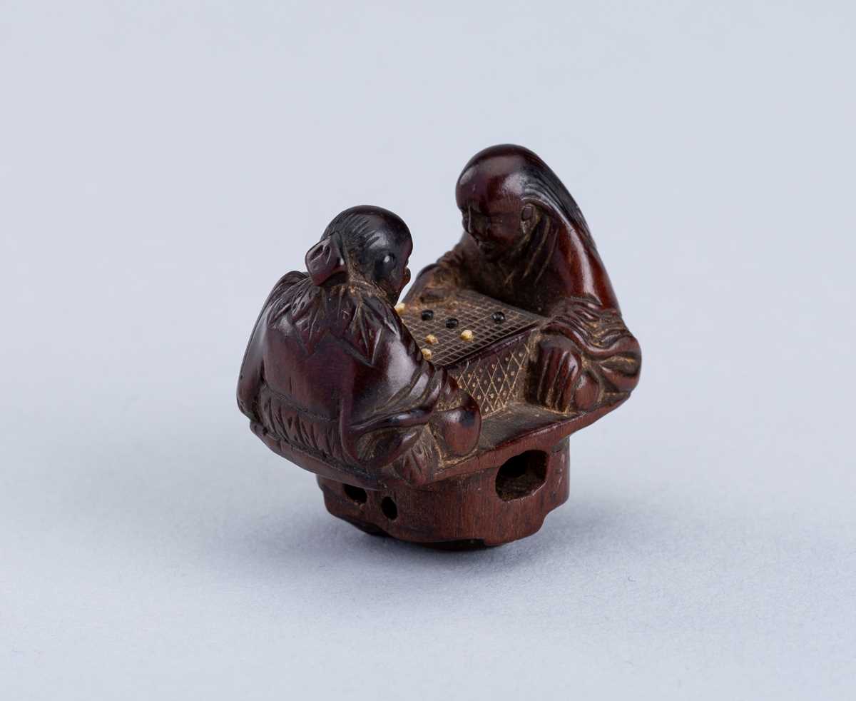 Lot 380 - INTERIOR OF A WOOD KARAKURI NETSUKE WITH TWO IMMORTALS PLAYING SUGOROKU, EDO PERIOD