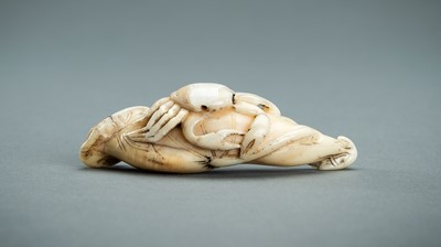 Lot 879 - AN IWAMI SCHOOL BOAR’S TOOTH NETSUKE OF A CRAB ON LOTUS LEAF, EDO