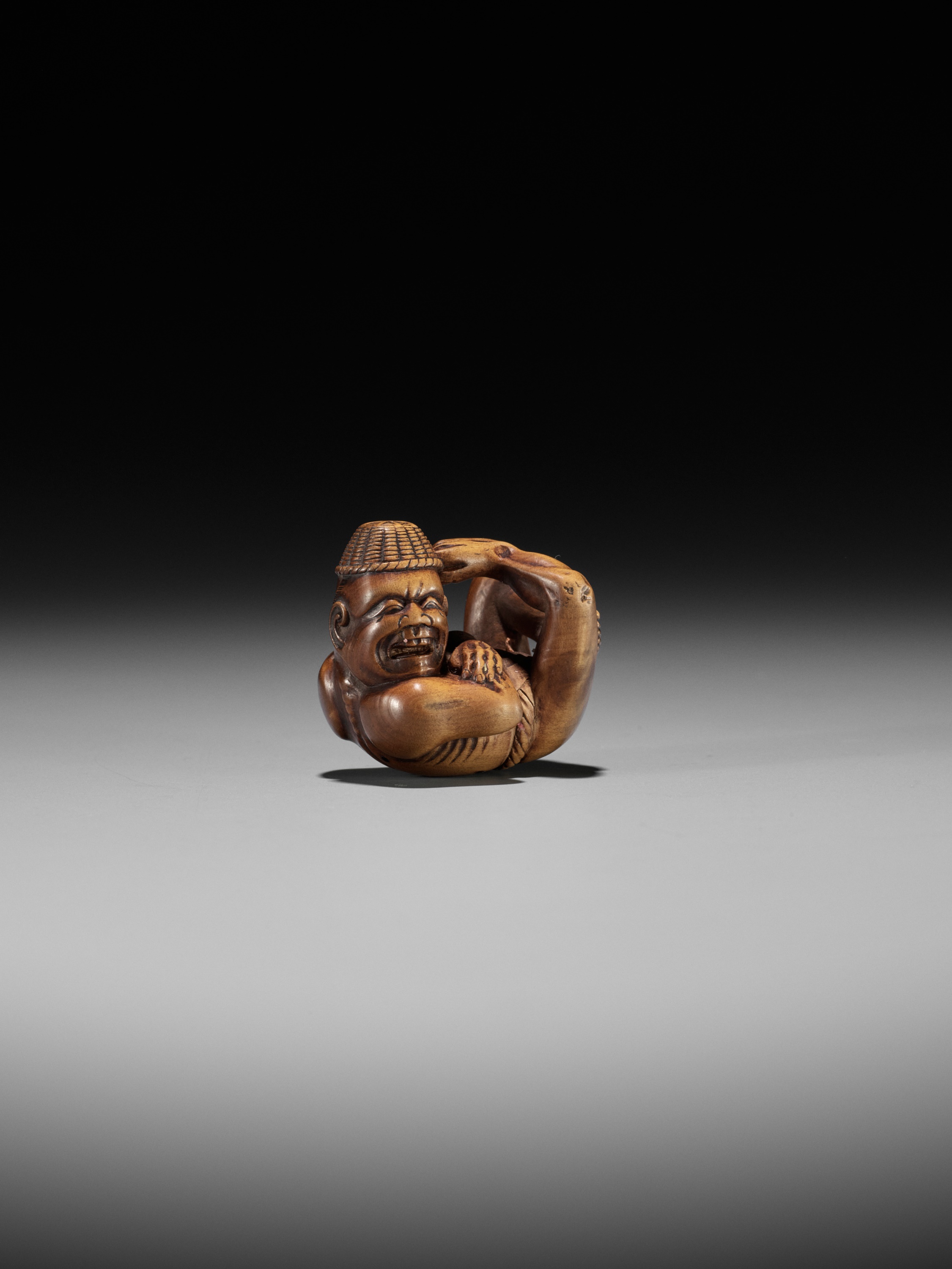 Lot 174 - AN AMUSING EDO SCHOOL WOOD NETSUKE OF A MOXA