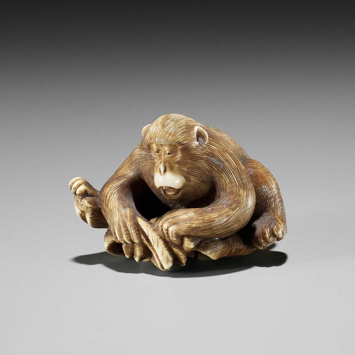 Lot 334 - AN IVORY NETSUKE OF A MONKEY, CRAB AND LOTUS