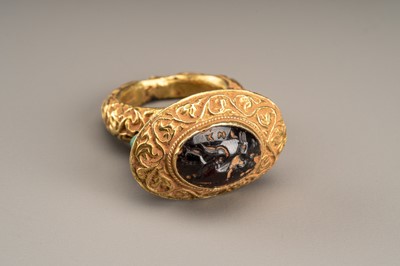 Lot 630 - A FINE GARNET INTAGLIO SET GANDHARAN GOLD RING