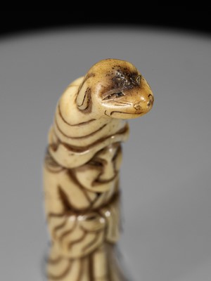 Lot 746 - A RARE STAG ANTLER NETSUKE OF A PUPPETEER WITH A DOG PUPPET ON HIS HEAD