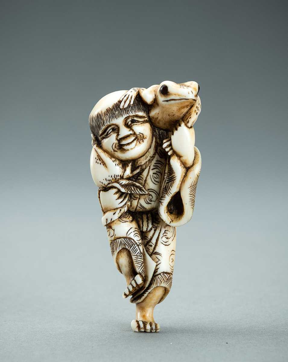 Lot 414 - YOSHINAGA: AN IVORY NETSUKE OF GAMA SENNIN, EDO PERIOD