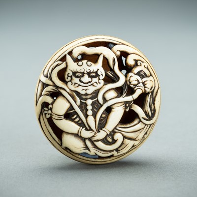 Lot 1367 - AN IVORY MANJU NETSUKE WITH AN ONI, EDO PERIOD