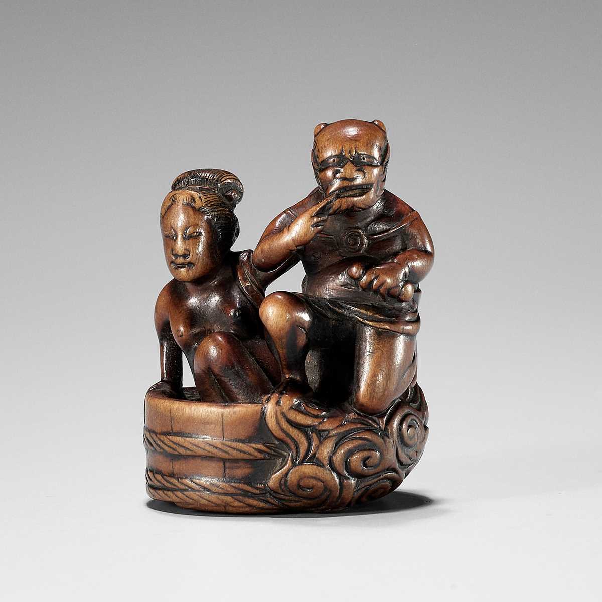 Lot 402 - HOMIN: A GOOD WOOD NETSUKE OF RAIJIN WITH BATHING WOMAN