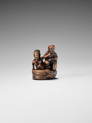 Lot 402 - HOMIN: A GOOD WOOD NETSUKE OF RAIJIN WITH BATHING WOMAN