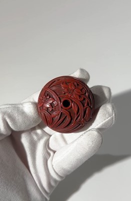Lot 280 - A FINE TSUISHU (CARVED RED LACQUER) MANJU NETSUKE WITH LILIES
