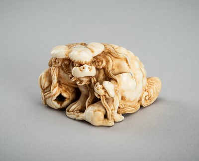 Lot 875 - AN IVORY NETSUKE OF A KARASHISHI WITH CUB, 19th CENTURY