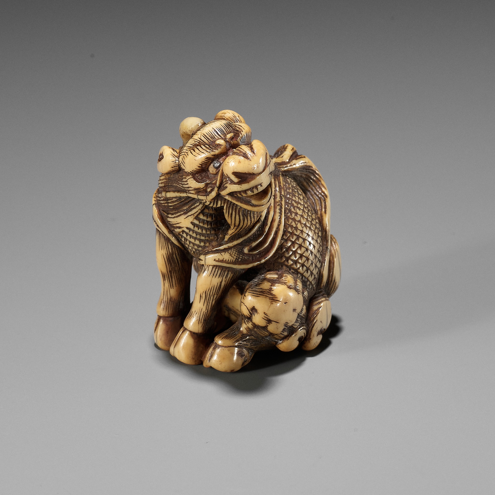 Lot 31 - GYOKUZAN: AN IVORY NETSUKE OF A KIRIN