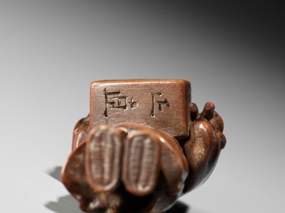 Lot 123 - MASANAO: A SMALL WOOD NETSUKE OF A BEAN VENDOR