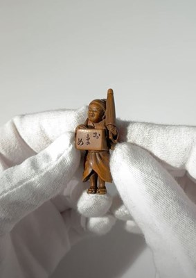 Lot 123 - MASANAO: A SMALL WOOD NETSUKE OF A BEAN VENDOR