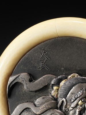 Lot 398 - TENMIN: A KAGAMIBUTA NETSUKE DEPICTING A NIO PULLING A GRIMACE