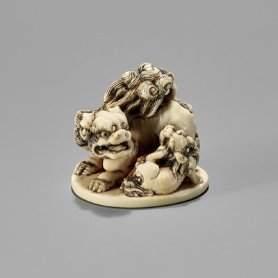 Lot 657 - TOSHINAGA: AN IVORY NETSUKE OF A SHISHI WITH YOUNG