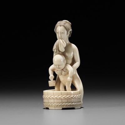 Lot 580 - A FINE IVORY OKIMONO OF A MOTHER BATHING HER CHILD