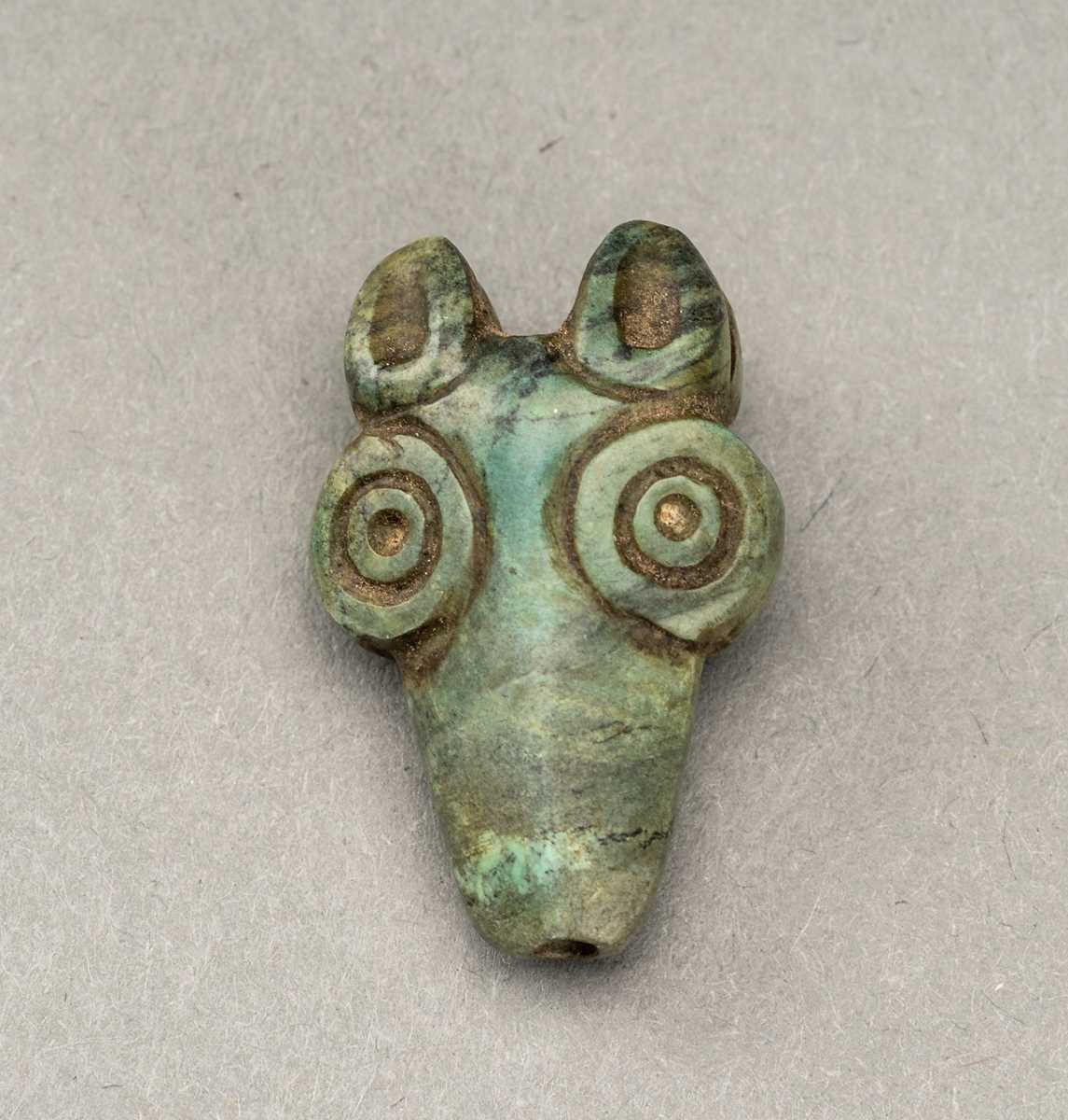 Lot 134 - AN ORDOS STYLE ‘WOLF HEAD’ TURQUOISE PENDANT
