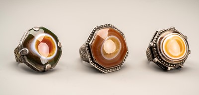 Lot 231 - A GROUP OF THREE HIMALAYAN BUDDHA EYE AGATE INSET SILVER RINGS