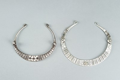 Lot 731 - A PAIR OF ENGRAVED TRIBAL SILVER AND METAL TORQUES, c. 1900s