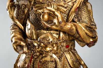 Lot 175 - A NEAR LIFE-SIZE GOLD LACQUERED WOOD FIGURE OF A GUARDIAN, QING