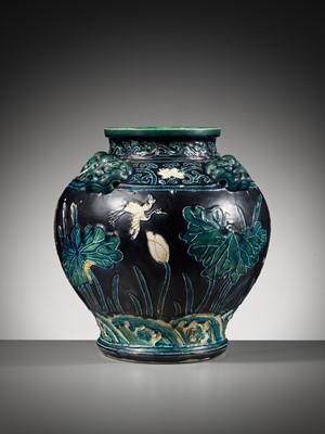 Lot 84 - AN EARLY FAHUA-GLAZED ‘LOTUS’ JAR, GUAN, WITH FOUR LION-MASK HANDLES, MING DYNASTY